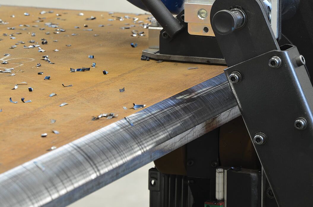 close-up of an industrial metal cutting machine trimming a steel sheet
