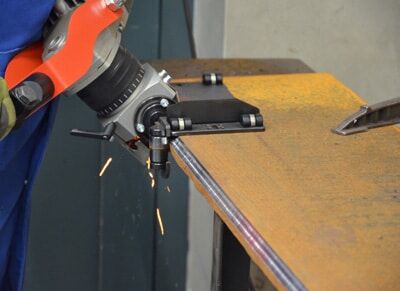 worker using an angle grinder to smooth the edge